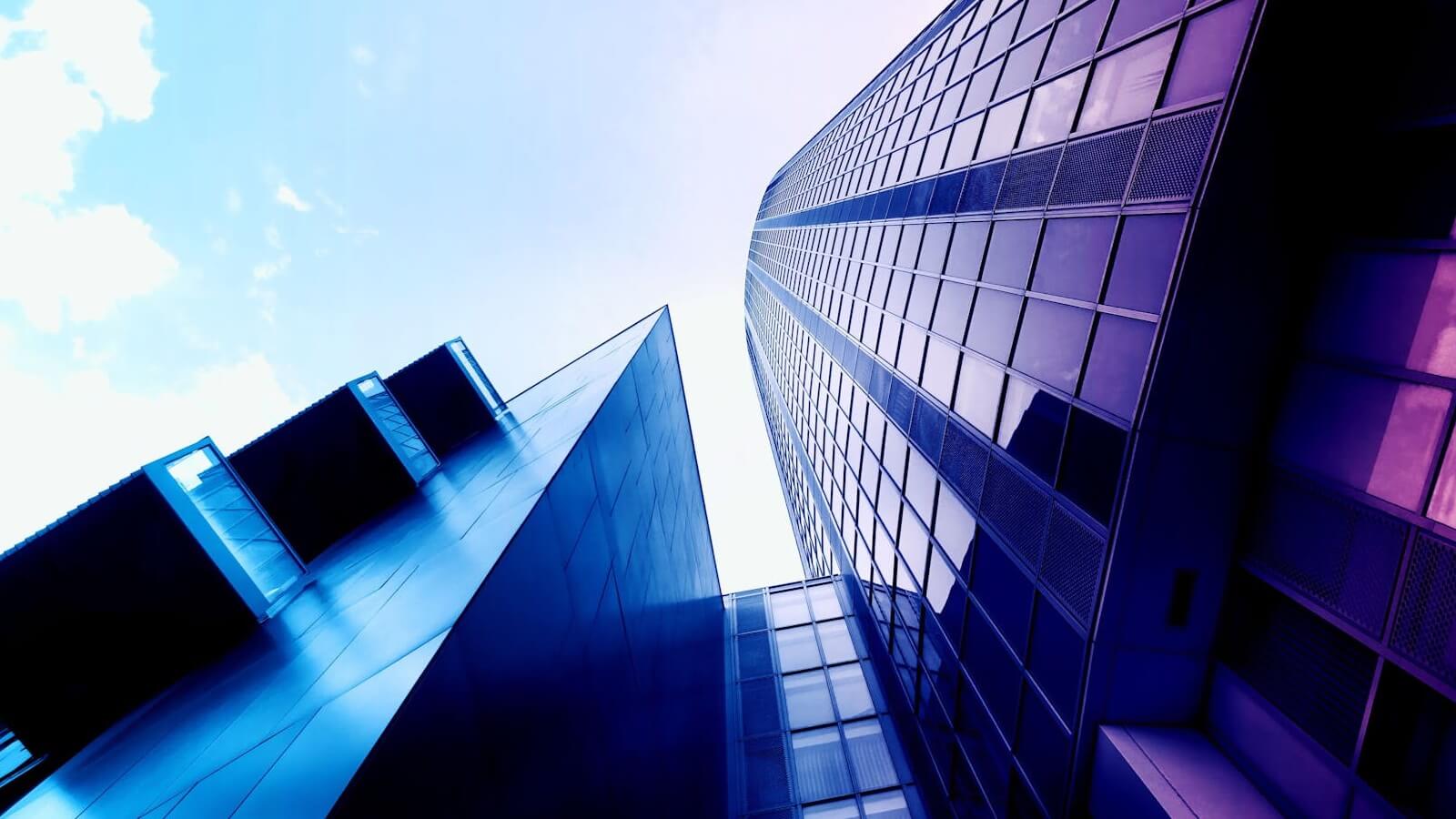 A commercial building towering into the sky tinted with a purple chromatic hue.